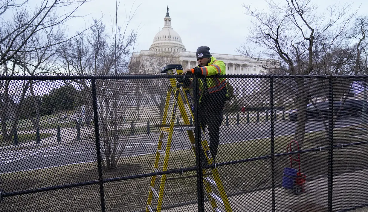 Seorang pekerja menyelesaikan pembangunan pagar pembatas di sekitar U.S. Capitol, di Washington, Minggu (5/2/2023). Pagar dipasang di sekitar Capitol sebelum pidato kenePidato kenegaraan "State of the Union" biasanya digunakan presiden Amerika Serikat untuk menyampaikan pencapaiannya selama setahun terakhir. (AP Photo/Anna Johnson)