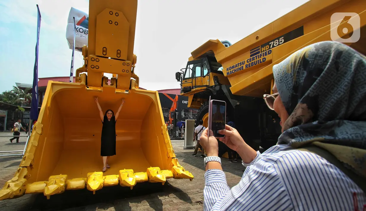 Pengunjung berfoto bersama produk terbaru alat berat Develon dalam pameran Mining Expo 2023 di JIExpo Kemayoran, Jakarta Kamis (14/9/2023). (Liputan6.com/Angga Yuniar)