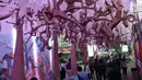 Pengunjung melihat-lihat karya seni instalasi dari bahan bekas pakai yang dipamerkan terowongan Jalan Kendal, Jakarta, Selasa (20/8/2019). Pemeran seni instalasi ini bertajuk Kenali Sejarah Perkeretapianmu dengan konsep Eco Living Go Green. (Liputan6.com/Helmi Fithriansyah)