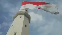 Foto: Bendera merah putih raksasa dikibarkan di puncak menara Suar Kupang, NTT (Liputan6.com/Ola Keda)