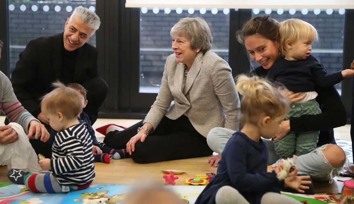 Suasana saat Perdana Menteri Inggris Theresa May bermain dengan bayi di pusat kesehatan di London, Inggris, Kamis (22/11). Selain menjadi PM Inggris, Theresa juga menjabat sebagai Ketua Partai Konservatif sejak tahun 2016. (Andrew Matthews/Pool via AP)