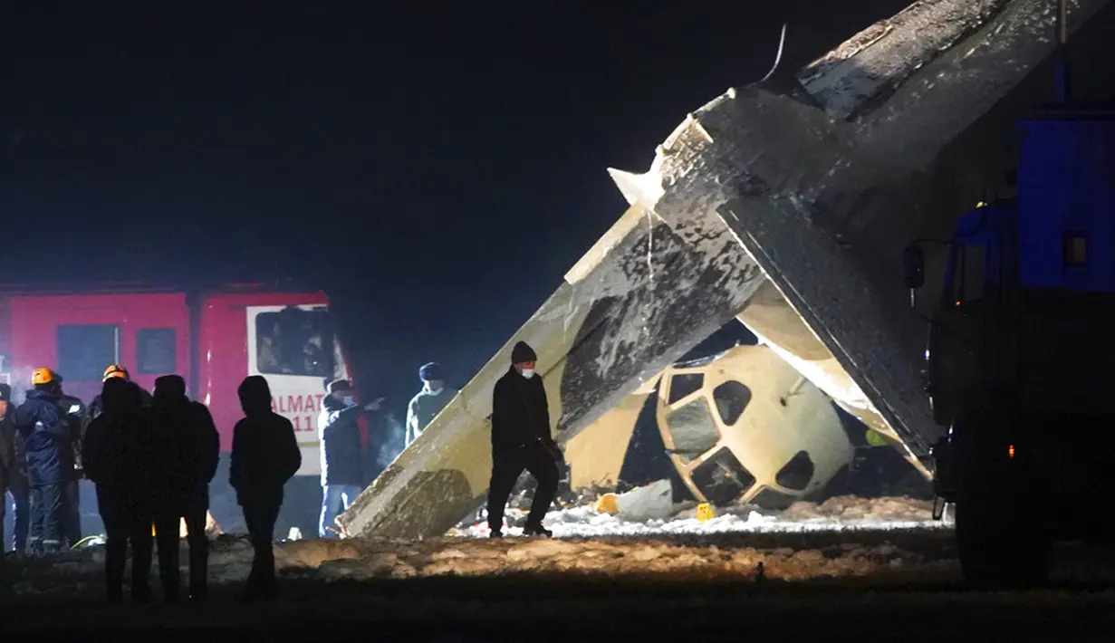 Pekerja darurat bekerja di samping pesawat Antonov An-26 yang jatuh di Bandara Almaty, Kazakhstan, Sabtu (13/3/2021). Pesawat Antonov An-26 tersebut terbalik dan terbakar di Bandara Almaty. (AP Photo/Vladimir Tretyakov)