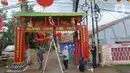 Warga memasang lampion dan menghias gapura dengan pernak-pernik imlek di Kampung Haji Bona, Depok, Jawa Barat, Kamis (19/1/2023). Bagi masyarakat Tionghoa, Imlek merupakan hari raya yang dirayakan sangat meriah oleh masyarakat keturunan China di seluruh dunia. (merdeka.com/Arie Basuki)