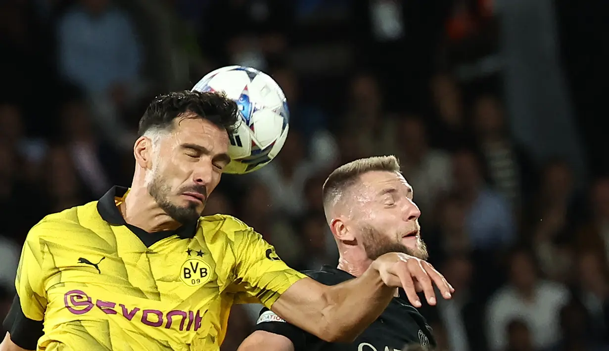 Bek Borussia Dortmund #15 Mats Hummels (Kiri) melompat untuk mengejar bola bersama bek Paris Saint-Germain #37 Milan Skriniar dalam matchday 1 Grup F Liga Champions 2023/2024 di Stadion Parc de Princes, Rabu dinihari WIB (20/9/2023). (FRANCK FIFE / AFP)