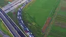 Pandangan udara kendaraan terjebak kemacetan saat keluar tol Pejagan, Jawa Tengah, Sabtu (2/7). Kemacetan panjang hingga 18 km terjadi dikarenakan antrean saat pembayaran pintu tol keluar. (Liputan6.com/Balgo Marbun)