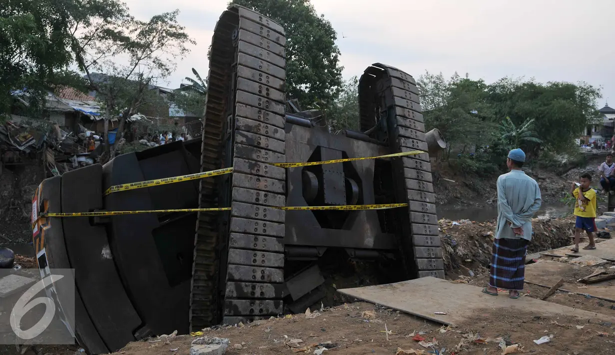 Warga melihat Crane yang jatuh ke Sungai Ciliwung Kelurahan Bukit Duri, Jakarta Selatan  (1/10/15). Akibatnya seorang warga RT15/10 Kelurahan Bukit Duri, Jakarta Selatan harus mendapatkan perawatan medis. (Liputan6.com/Gempur M Surya)