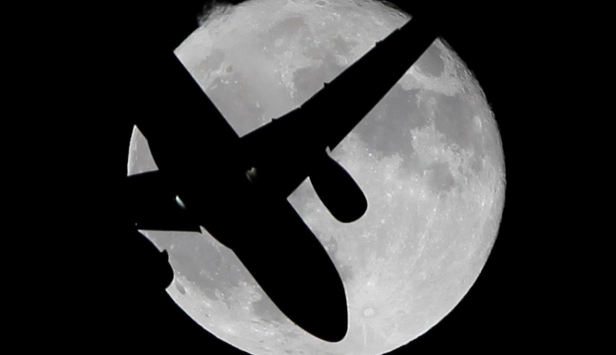 Siluet pesawat pada saat fenomena Supermoon yang muncul di atas langit Ronda, Spanyol, Senin (17/10). Dalam fenomena tersebut, bulan purnama terlihat lebih besar dan terang karena berada di jarak terdekat dengan bumi. (Reuters/Jon Nazca)