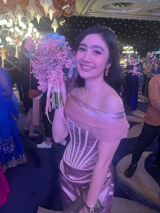 Sedangkan untuk acara resepsi pernikahan Jessica Mila-Yakup Hasibuan, Febby memesona dalam balutan gaun berwarna rose gold. Gaun off-the-shoulder ini membalut tubuh Febby dengan sempurna, memiliki detail high slit. Foto: Instagram.