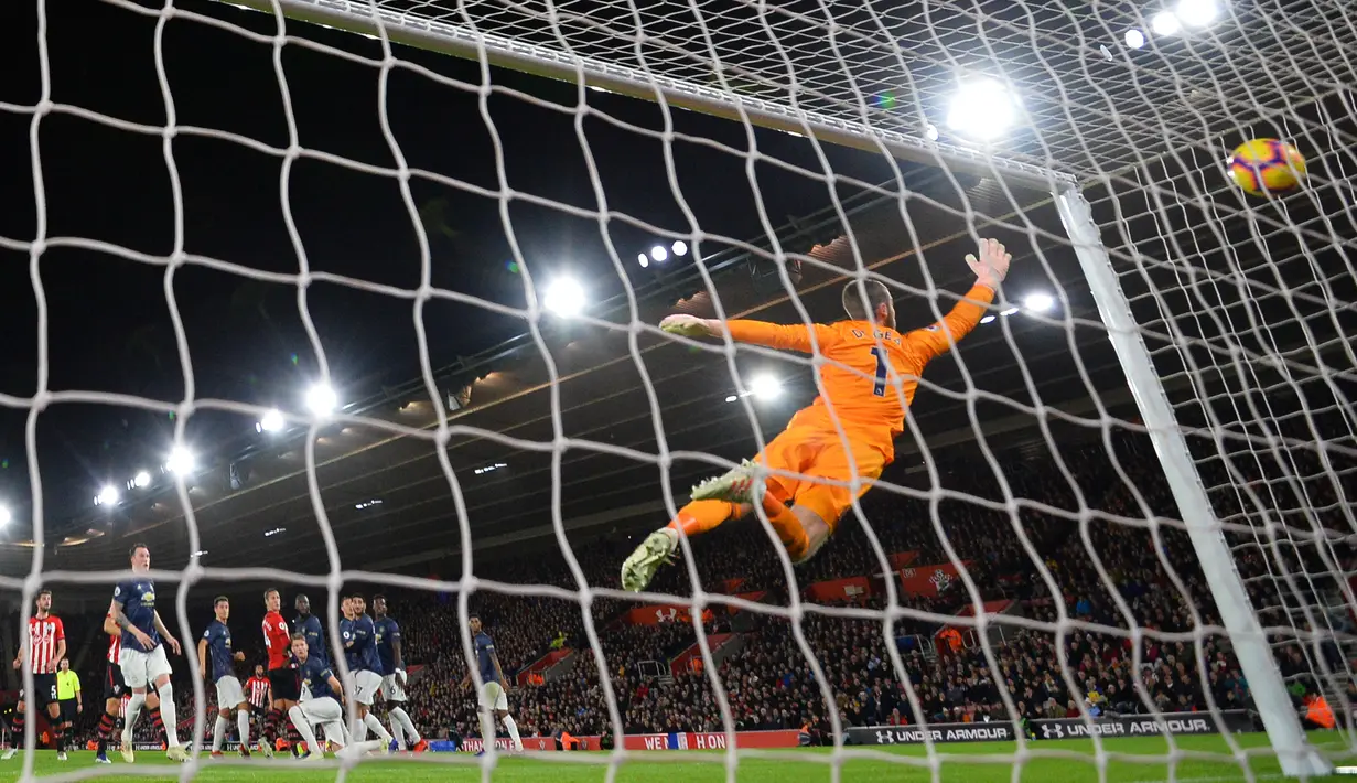 Kiper Manchester United, David De Gea, gagal mengamankan bola saat melawan Southampton pada laga Premier League di Stadion St Mary, Southampton, Sabtu (1/12). Kedua klub bermain imbang 2-2. (AFP/Glyn Kirk)