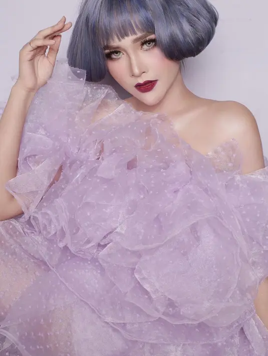 Penampilan sangat berbeda lainnya dari Bella Bonita bak boneka hidup. Kali ini dengan wig super pendek berwarna abu-abu kebiruan, makeup bold dengan pulasan lipstik merah, dan outfit ungu yang serasi, Bella Bonita tampil beda dan unik. Foto: Instagram.