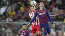 Penyerang Barcelona, Antoine Griezmann melompat saat berebut bola dengan pemain Atletico Madrid, Saul pada laga semifinal Piala Super Spanyol di King Abdullah Sports City, Jeddah, Kamis (9/1/2020). Barcelona harus menjalani pertandingan yang dramatis saat kalah 2-3 dari Atletico. (AP/Hassan Ammar)