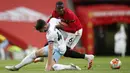 Pemain Manchester United, Paul Pogba, berebut bola dengan pemain West Ham United, Declan Rice, pada laga Premier League di Stadion Old Trafford, Rabu (22/7/2020). Kedua tim bermain imbang 1-1. (Clive Brunskill/Pool via AP)