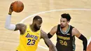 Pebasket Los Angeles Lakers, LeBron James, berusaha melewati pebasket Memphis Grizzlies, Dillon Brooks, pada laga NBA, Rabu (6/1/2021). LA Lakers menang tipis 94-92 atas Grizzlies. (AP Photo/Brandon Dill)