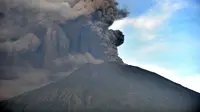 Semburan abu vulkanik Gunung Agung terlihat dari sebuah desa di Kecamatan Kubu, Karangasem, Bali, Minggu (26/11). Semburan asap dan abu vulkanik Gunung Agung mencapai ketinggian 1.500 meter dari puncak Gunung Agung. (AFP/Sonny Tumbelaka)
