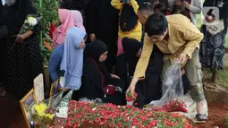 Seorang kerabat menabur bunga saat pemakaman Abdul Hamid alias Pak Ogah di TPU (Tempat Pemakaman Umum) Jatisari, Bekasi, Jawa Barat, Kamis (29/12/2022). Pak Ogah salah satu pengisi suara dalam serial film Si Unyil meninggal pada (28/12/2022) di usia 74 tahun. (Liputan6.com/Herman Zakharia)