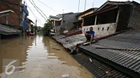 Warga berada di atap rumahnya di kawasan Perumahan Pondok Gede Permai, Bekasi, Jawa Barat, Kamis (21/4). Banjir dengan ketinggian tiga meter yang berasal dari meluapnya Sungai Cikeas. (Liputan6.com/ Immanuel Antonius)