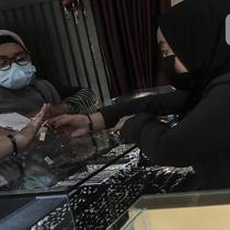 Calon pembeli mencoba cincin emas di Pegadaian, Jakarta, Selasa (18/5/2021). Untuk emas Antam satuan terkecil dengan ukuran 0,5 gram dijual Rp 518.500, naik Rp 2.000 dari harga sebelumnya. (Liputan6.com/Johan Tallo)