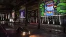 Orang-orang mengunjungi pameran seni dengan mengendarai mobil mereka melintasi gudang yang memajang lukisan dan foto di Sao Paulo pada 30 Juli 2020. Dengan galeri-galeri dan museum ditutup akibat pandemi virus corona, pemilik galeri seni Brasil meresmikan pameran drive-thru. (NELSON ALMEIDA/AFP)