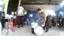 Anggota polisi  mengambil makan siang di pos pengamanan 06 exit tol Brebes Timur, Jawa Tengah, Sabtu (9/7). Anggota Satlantas Polres Brebes sedang mempersiapkan makanan siang untuk anggota kepolisian yang sedang bertugas. (Liputan6.com/Herman Zakharia)