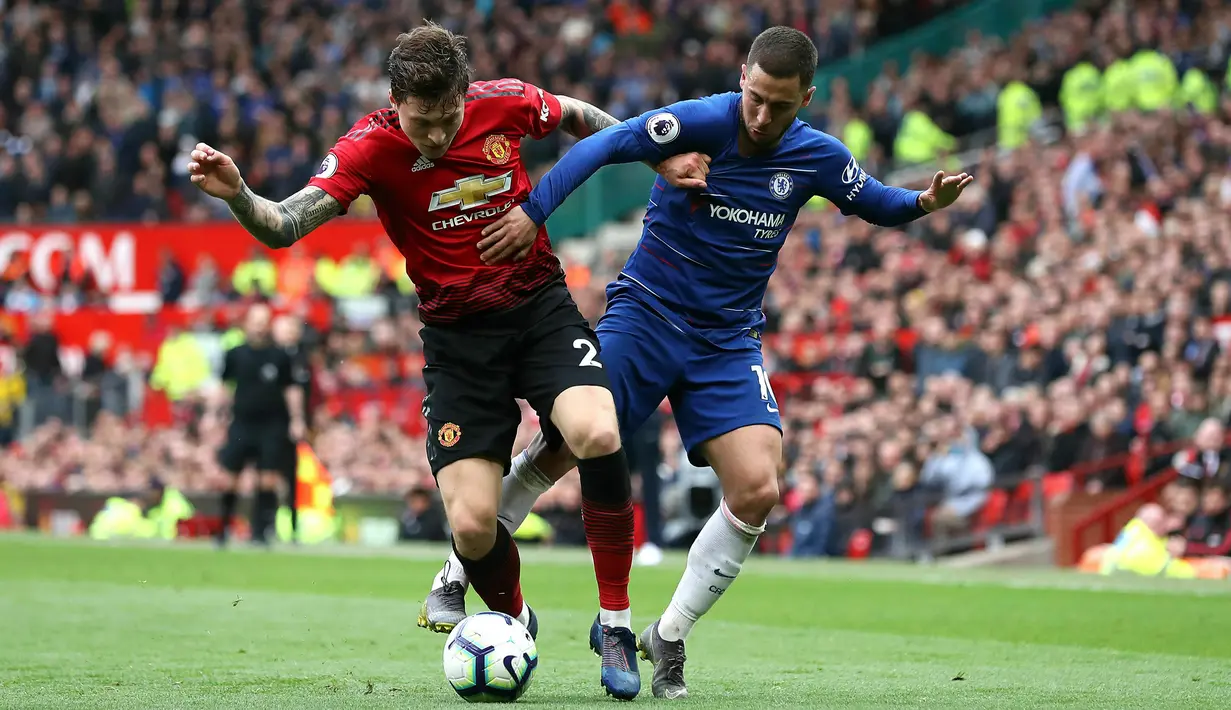 Pemain Manchester United Victor Lindelof (kiri) dan pemain Chelsea Eden Hazard (kanan) berebut bola saat bertanding dalam lanjutan Liga Inggris 2018-2019 di Old Trafford, Manchester, Inggris, Minggu (28/4/2019). Pertandingan berakhir dengan skor 1-1. (Martin Rickett/PA via AP)