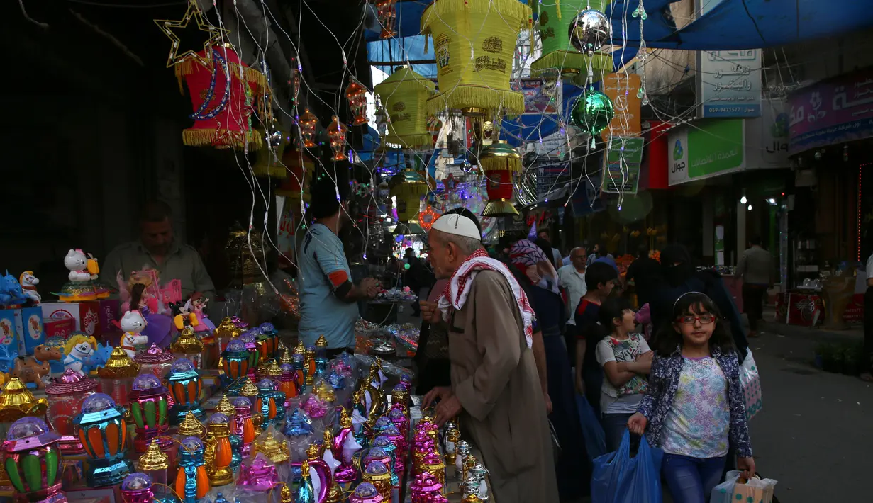 Seorang kakek membeli lentera Ramadan yang dijajakan salah satu kios di pasar Kota Gaza, Kamis (25/5). Warga Palestina merayakan datangnya bulan puasa dengan memasang lentera tradisional khas Ramadan sebagai dekorasi rumah. (AP Photo/Adel Hana)
