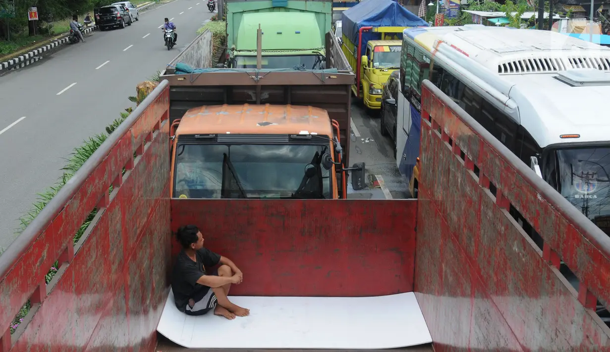 <p>Kernet truk beristirahat saat antrian truk menuju  Pelabuhan Gilimanuk, Jembrana, Bali, Sabtu (304/2022). Pelabuhan Gilimanuk Bali dipadati oleh ribuan kendaraan pemudik yang akan menyeberang ke Pulau Jawa pada H-2 Hari Raya Idul Fitri 1443 H. (merdeka.com/Arie Basuki)</p>