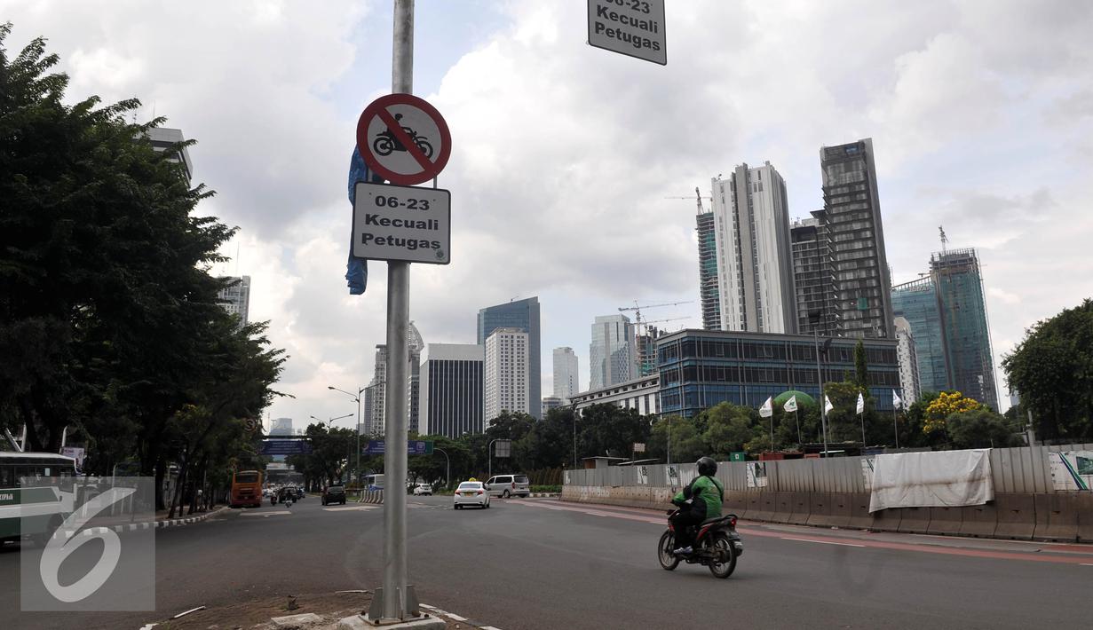 Pengendara motor melintasi jalan Sudirman, Sabtu, (30/4). Ditlantas Polda Metro akan menunggu pengadaan 600 bus terealisasi baru memberlakukan pelarangan sepeda motor dari kawasan Senayan hingga Thamrin. (Liputan6.com/Johan Tallo)