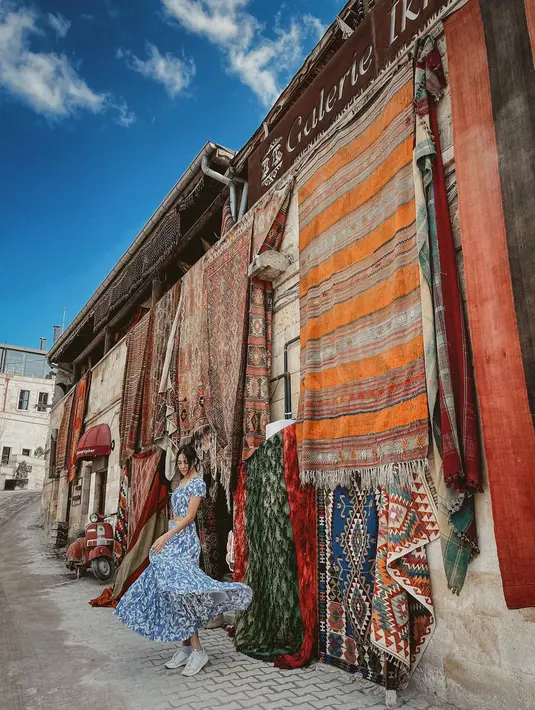 Outfit feminin ini ditutup dengan sneakers putih abu-abu [@anyageraldine]