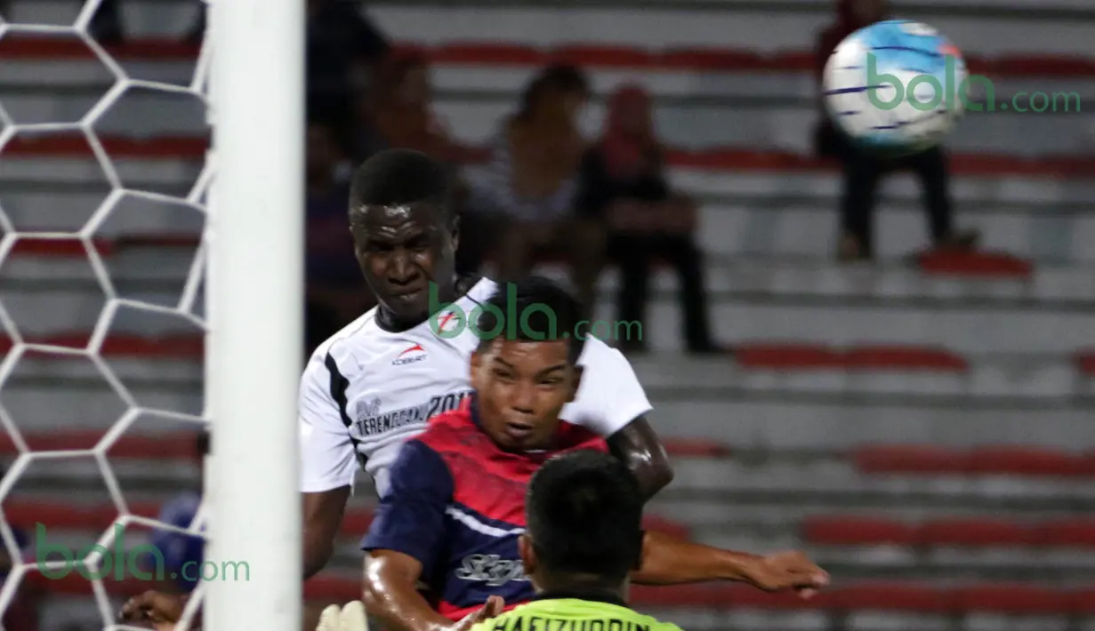 Bek T-Team Malaysia, Abdoulaye Maiga, duel udara dengan pemain ATM FA pada laga play-off Malaysia Super League 2016. (Bola.com/Nicklas Hanoatubun)