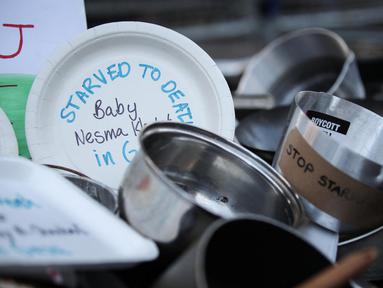 Sebuah foto yang diambil pada 25 Juli 2025 menunjukkan panci-panci masak yang bertuliskan “Mati kelaparan di Gaza” tergeletak di tanah di luar gerbang Downing Street, di pusat kota London, Inggris. (Rhianna Chadwick/AFP)