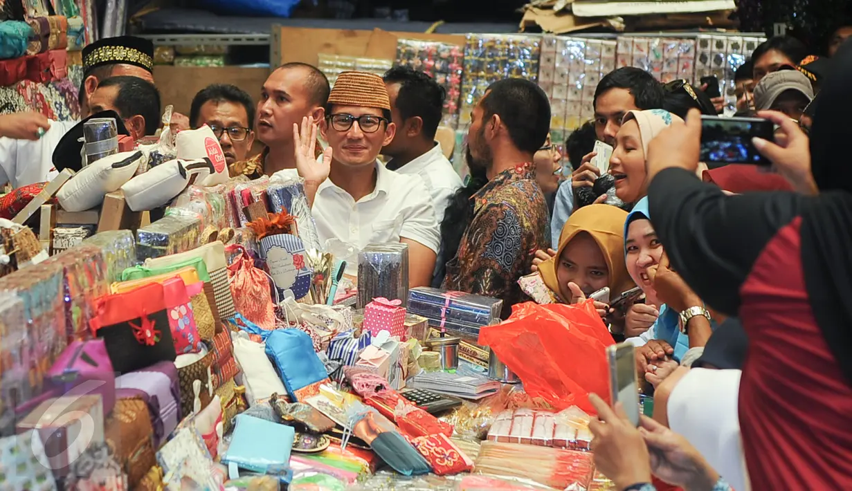 Wakil Gubernur terpilih DKI Jakarta Sandiaga Uno melambaikan tangan saat menyambangi Pasar Jatinegara, Jakarta Timur, Jumat (12/5). Selain menemui pedagang, Sandiaga Uno juga melaksanakan salat Jumat di Masjid Pasar Jatinegara. (Liputan6.com/Yoppy Renato)