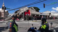 Polisi berkumpul di depan reruntuhan restoran cepat saji Jollibee setelah gempa bumi berkekuatan magnitudo 7,8 di Kota General Santos, Filipina, pada Senin 8 Juni 2026. (Edwin Espejo/AFP)