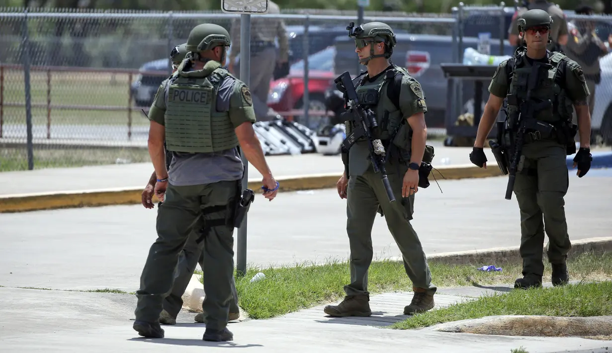 Aparat penegak hukum berdiri di luar Robb Elementary School setelah penembakan, Uvalde, Texas, Amerika Serikat, 24 Mei 2022. Ini merupakan insiden paling parah dalam sejarah Texas. (AP Photo/Dario Lopez-Mills)