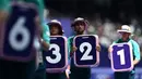 Para volunteer sedang bersiap memasang nomor lintasan untuk nomor lari 800m putra cabang atletik Olimpiade Paris 2024 di Stade de France, Paris, Prancis pada 7 Agustus 2024. (AFP/Jewel Samad)
