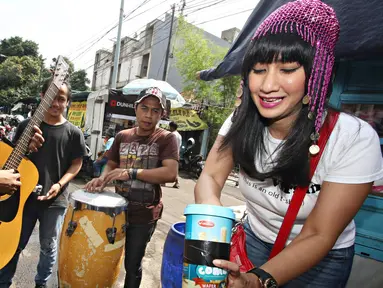 Cut Memey memeriksa uang hasil mengamen di kawasan Blok M, Jakarta Selatan, Senin (7/12/2015). Dalam rangka merayakan HUT-nya yang ke-35, Cut Memey dan sejumlah pengamen tampil untuk menghibur warga saat jam makan siang. (Liputan6.com/Immanuel Antonius)