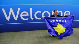 Seorang delegasi sepak bola Kosovo berfoto dekat tulisan selamat datang  saat merayakan diterimnya Kosovo sebagai anggota UEFA pada kongres UEFA ke-40 tahun di Hungexpo Fair Center, Budapest, Hungary, (3/52016). (AFP/Attila Kisbenedek)