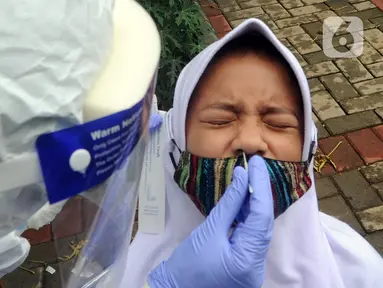 Ekspresi seorang anak saat menjalani swab test massal di Puskesmas Ciganjur, Jakarta Selatan, Kamis (7/1/2020). Swab test gratis yang diadakan oleh Sudinkes Jakarta Selatan tersebut dilakukan terhadap puluhan warga. (merdeka.com/Arie Basuki)