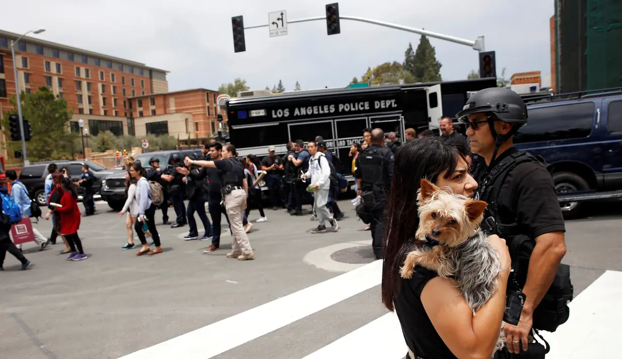 Para mahasiswa meninggalkan kampus setelah terjadinya penembakan di Universitas California Los Angeles (UCLA), Rabu (1/6). Polisi mencurigai penembakan yang menewaskan dua orang itu merupakan aksi bunuh diri. (REUTERS/Patrick T. Fallon)