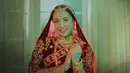 Melengkapi tampilannya dengan tudung merah khas India. Sama seperti atasannya, kerudung tersebut pun memiliki bordiran emas. [YouTube Dewa19]