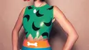 Hailey Bieber tahun ini menjadi karakter Pebbles dari karakter Flintstones. Mengenakan wig warna merah dengan busana atasan hijau dan rok birunya. [@haileybieber]