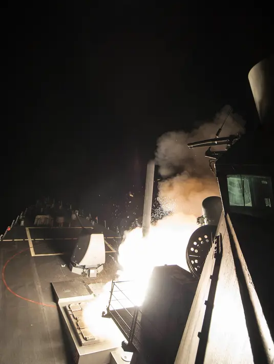 Kapal perang AS meluncurkan rudal Tomahawk ke pangkalan udara Suriah dari Laut Mediterania , Jumat (7/4). Serangan ini adalah perintah militer Donald Trump pertama sejak memegang jabatan sebagai Presiden AS. (MC3 (SW) Robert S. Price /U.S. Navy via AP)