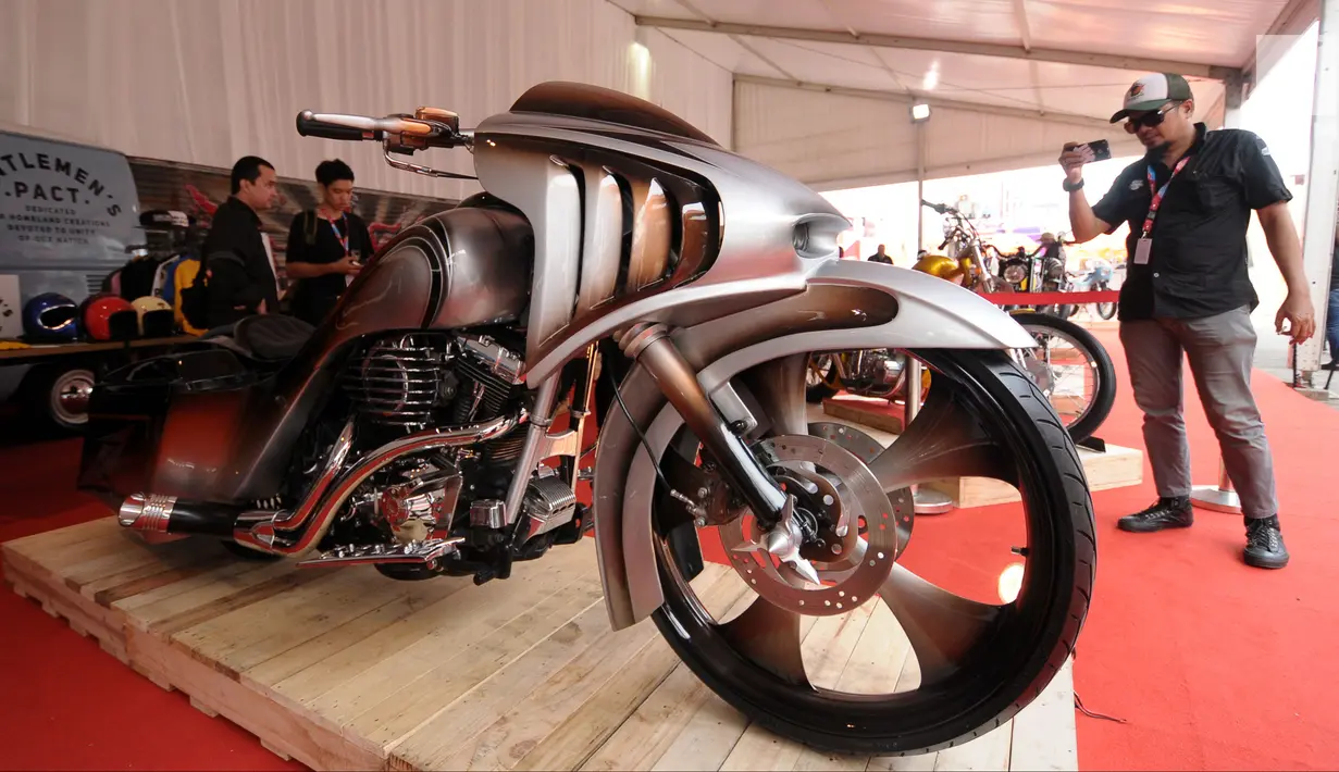 Pengunjung mengabadikan salah satu motor custom yang dipamerkan pada Indonesia International Motor Show 2018 di JIExpo, Jakarta, Kamis (19/4). IIMS 2018 diselenggarakan hingga 29 April mendatang. (Liputan6.com/Helmi Fithriansyah)