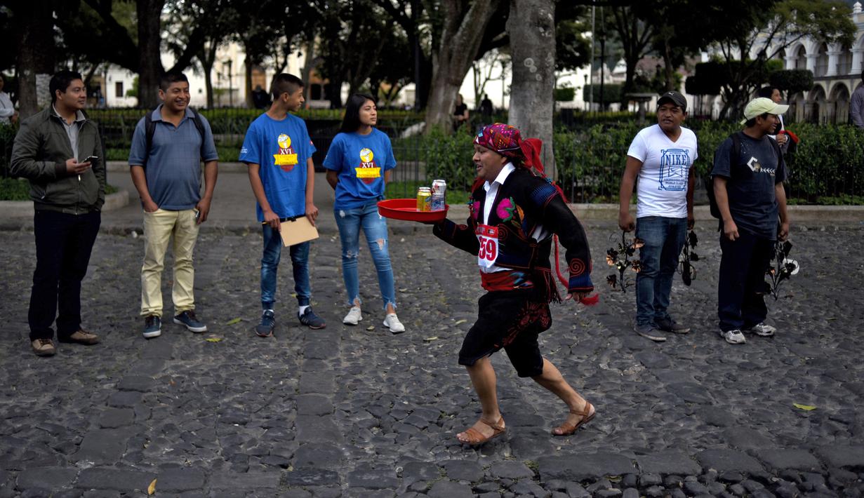 Seorang pramusaji beradu kecepatan sambil membawa nampan dalam Waiters Race ke-16 di Antigua, barat daya Ibu Kota Guatemala City, Rabu (14/11). Lomba ini diikuti oleh ratusan peserta yang merupakan pelayan restoran dan kafe setempat. (JOHAN ORDONEZ/AFP)