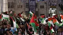 Warga Palestina melambaikan bendera nasional mereka saat menunggu live-screening pidato Presiden Mahmud Abbas sebelum pengibaran bendera Palestina di markas besar PPB di New York, Rabu (30/9/2015). (AFP PHOTO/ABBAS Momani)