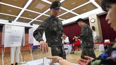 Tentara Korea Selatan (Korsel) memasukkan kertas suara di sebuah TPS di Seoul, Kamis (4/5). Selama 2 hari, masyarakat yang terdaftar sebagai pemilih dapat memberikan suara sebelum pemilihan presiden (Pilpres) pada 9 Mei mendatang. (JUNG Yeon-Je/AFP)