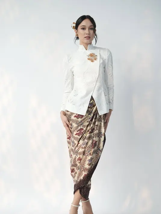 Ikuti tren kebaya janggan, Yasmin Napper tampil bak Jeng Yah dengan kebaya janggan putih. Dipadu dengan wrapped skirt batik bersiluet pensil dan bros emas besar [@yasminnapper]