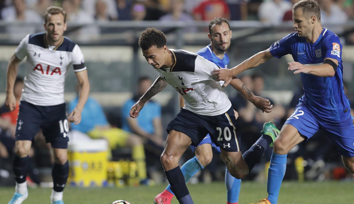 Pemain Tottenham, Dele Alli, berusaha melewati adangan pemain Kitchee Sports Club, Krisztian Vadocz, pada laga persahabatan di Hong Kong, (26/5/2017). Tottenham menang 4-1. (AP/Kin Cheung)