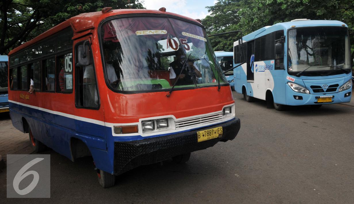 Kopaja melintas disamping  Kopaja terintegrasi Transjakarta yang terparkir di Parkir Timur Senayan, Jakarta, Selasa (22/12). Rute yang terintegrasi dengan koridor IV Dukuh Atas-Pulogadung, koridor V Ancol-Kampung Melayu. (Liputan6.com/Johan Tallo)