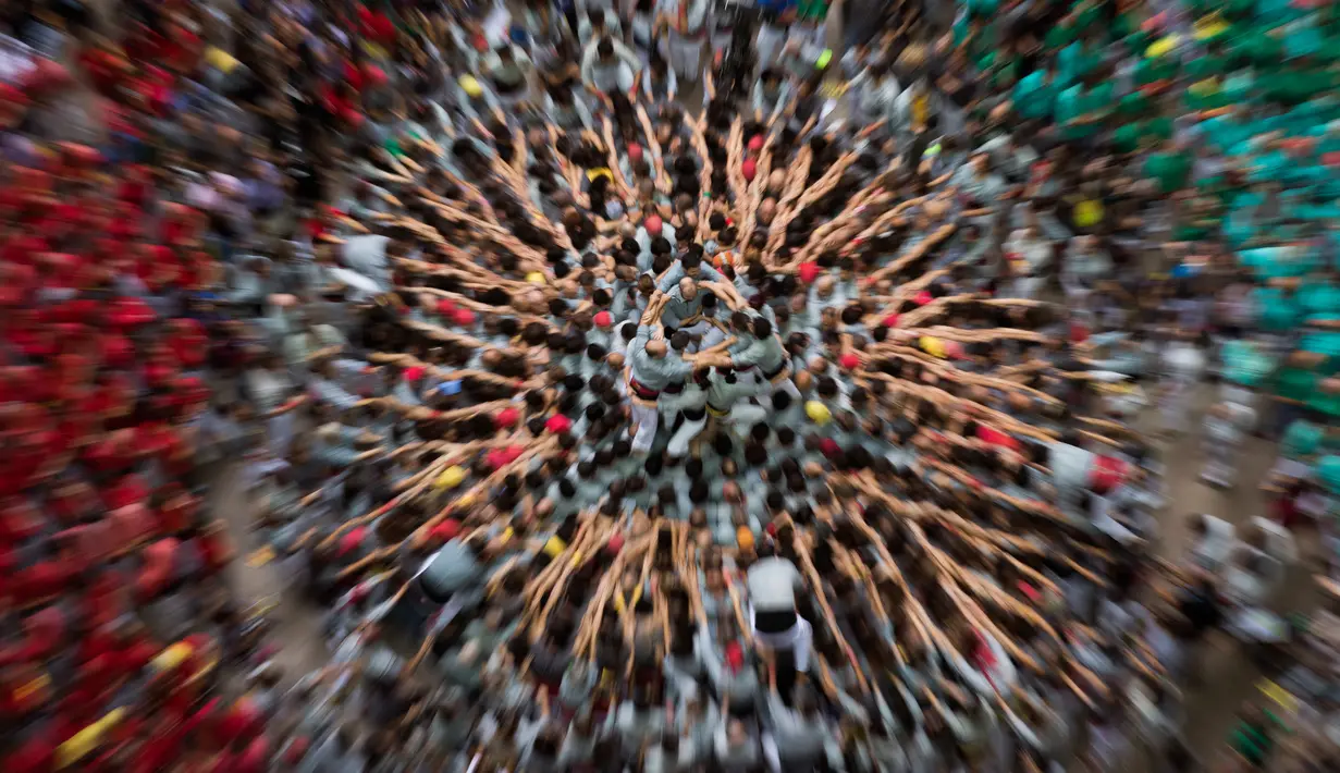 Anggota "Castellers de Sants" membentuk menara manusia selama Kompetisi Tower Manusia di Tarragona, Spanyol, Minggu (7/10). Sejak 2010, Tradisi "Castells" atau "Menara Manusia" telah masuk ke dalam daftar warisan budaya dunia UNESCO. (AP/Emilio Morenatti)