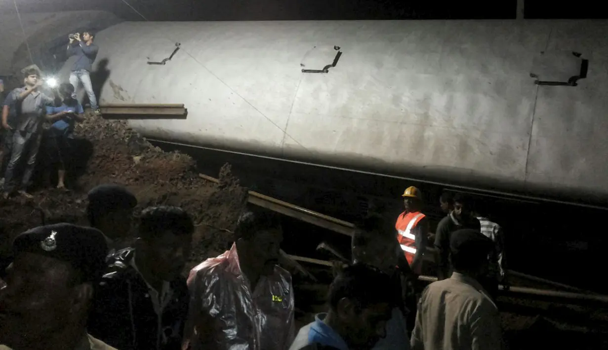 Petugas penyelamat berusaha mengevakuasi kereta penumpang yang keluar dari rel di Negara Bagian Madhya Pradesh, India, Selasa (4/8/2015). Beberapa gerbong dari kedua kereta penumpang tersebut jatuh ke sungai yang meluap. (REUTERS/ANI/Handout via Reuters)